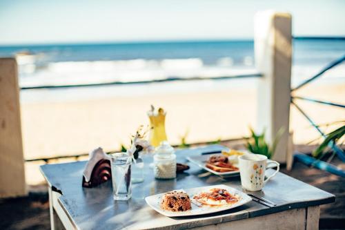 拉斯佩尼塔斯的住宿－Casita de Playa BOMALU，海滩上一张桌子,上面放着两盘食物