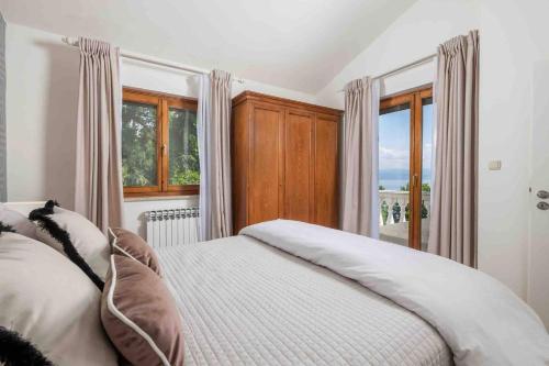 a bedroom with a bed and a large window at Villa The Nest in Opatija