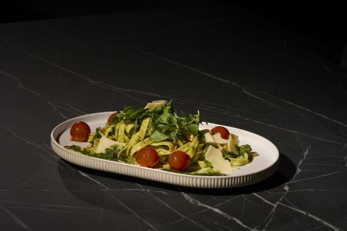 a plate of food with broccoli and tomatoes on a table at Hotel Rhönkitz in Bad Kissingen