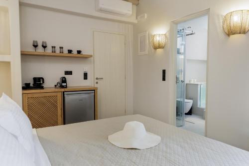 un sombrero blanco sentado en la parte superior de una cama en Aesthete Suites, en Agia Anna de Naxos