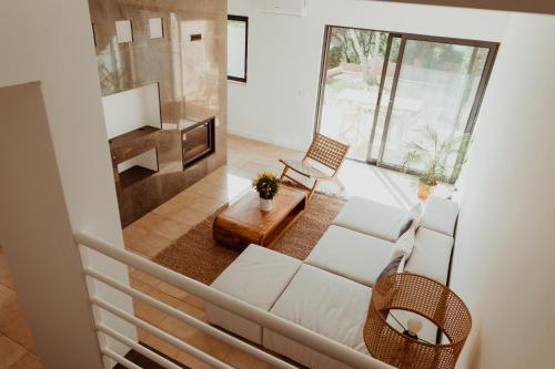 een woonkamer met een witte bank en een piano bij Edition Albufeira / Stargazing terrace + Pool in Albufeira
