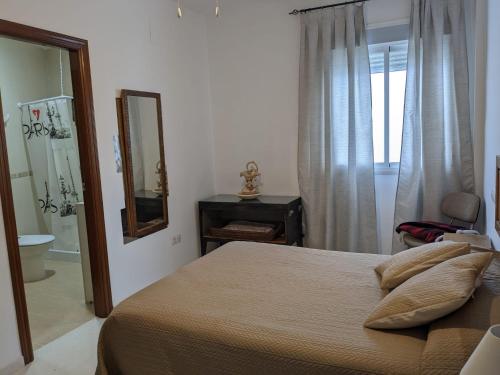 1 dormitorio con cama y baño con espejo. en CasaBaena Rafi en Baena