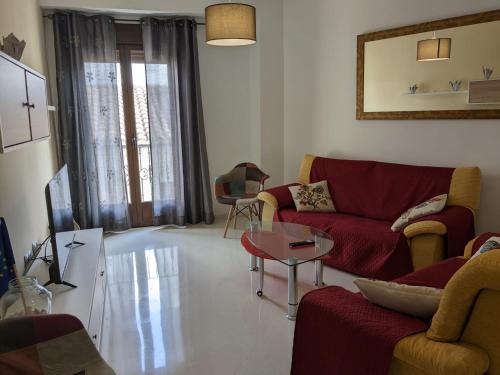 sala de estar con sofá rojo y mesa en CasaBaena Rafi en Baena