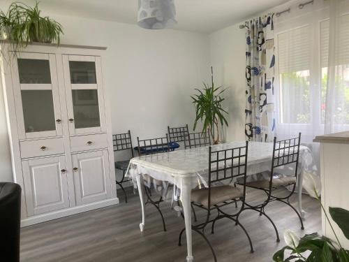 uma sala de jantar com uma mesa branca e cadeiras em Instant d'Evasion em Bar-sur-Aube