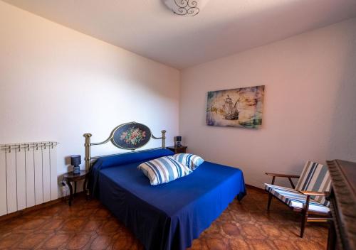 a bedroom with a bed with a blue bedspread at Super Terrace in Porto Santo Stefano