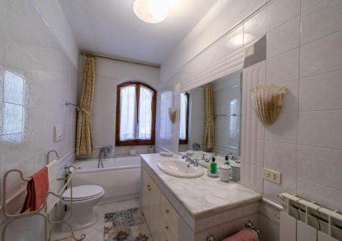 a bathroom with a sink and a tub and a toilet at Super Terrace in Porto Santo Stefano