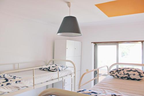 a room with two bunk beds and a lamp at Villa do Sol Carcavelos Beach House in Carcavelos