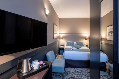 a hotel room with a bed and a flat screen tv at Best Western Plus Nice Cosy Hotel in Nice