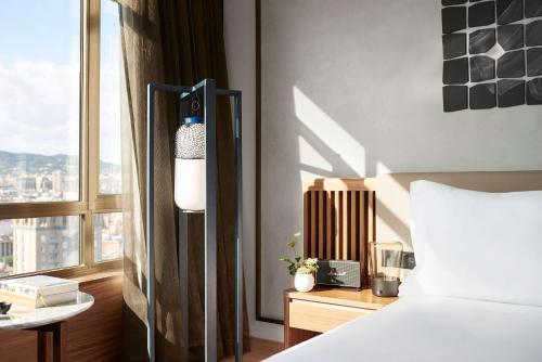 a bedroom with a white bed and a window at Nobu Hotel Barcelona in Barcelona