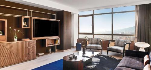 a living room with a couch and a tv at Nobu Hotel Barcelona in Barcelona