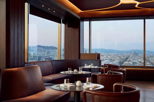 a restaurant with tables and chairs and a view of a city at Nobu Hotel Barcelona in Barcelona