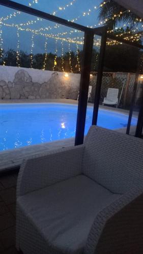 a chair sitting next to a swimming pool at night at i girasoli srls in Bari