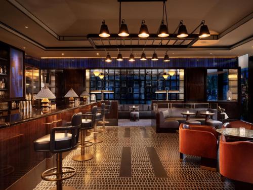 a restaurant with a bar with chairs and tables at Nobu Hotel London Portman Square in London