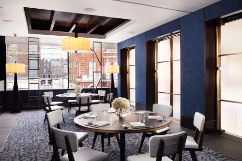a restaurant with blue walls and tables and chairs at Nobu Hotel London Portman Square in London