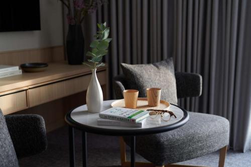 a coffee table with a vase and books and glasses at Nobu Hotel London Portman Square in London