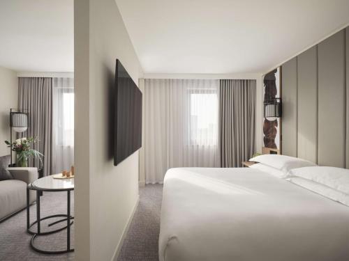 a hotel room with a large white bed and a table at Nobu Hotel London Portman Square in London
