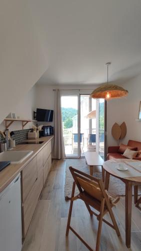 une cuisine et un salon avec une table et un canapé dans l'établissement Terracotta - T2 avec Terrasse proche de Cassis, à Roquefort-la-Bédoule