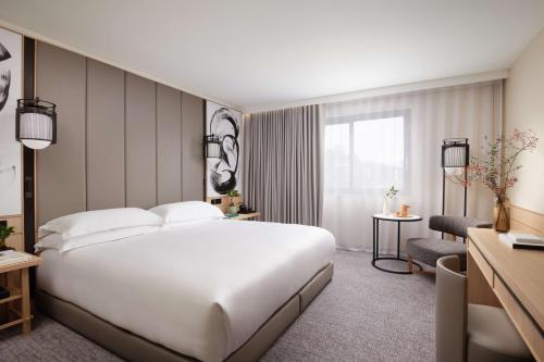 a hotel room with a large white bed and a window at Nobu Hotel London Portman Square in London