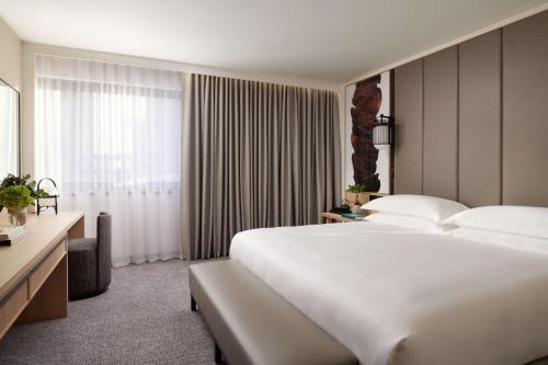 a hotel room with a large white bed and a window at Nobu Hotel London Portman Square in London
