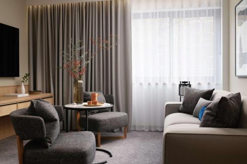 a living room with a couch and chairs and a table at Nobu Hotel London Portman Square in London