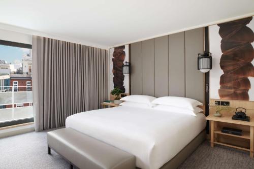 a bedroom with a large white bed and a window at Nobu Hotel London Portman Square in London