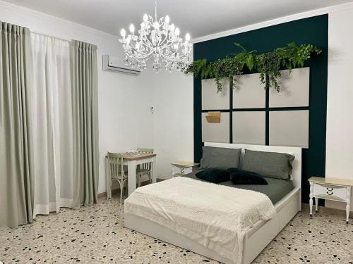 una camera con letto e lampadario a braccio di Cappuccini Green Relax a Carini