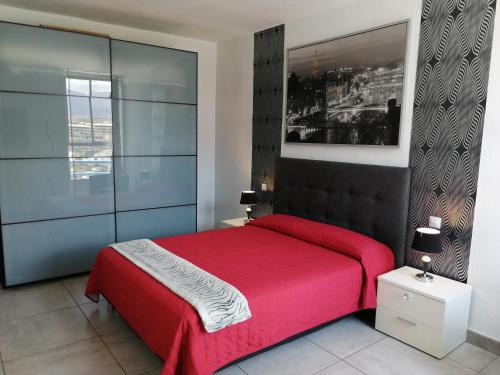 a bedroom with a red bed and a window at Amplio apartamento 1 dormitorio - Playa Paraiso in Playa Paraiso