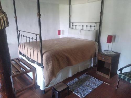 a bedroom with a bed and a wooden floor at Ambelikos Traditional Agrohotel in Potamitissa