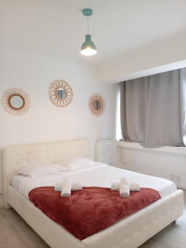 - une chambre blanche avec un grand lit blanc et une couverture rouge dans l'établissement Meyerbeer YourHostHelper, à Nice