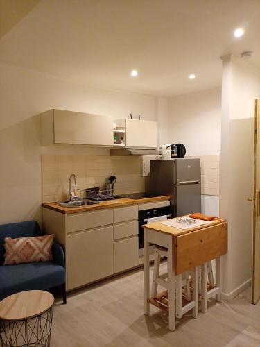 une petite cuisine avec une table et un canapé bleu dans l'établissement Meyerbeer YourHostHelper, à Nice