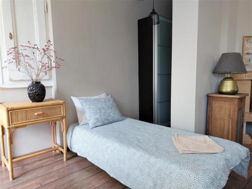 a bedroom with a bed and a table with a vase on it at Apartamenty NOVA na Krakowskiej No 1 in Bielsko-Biala