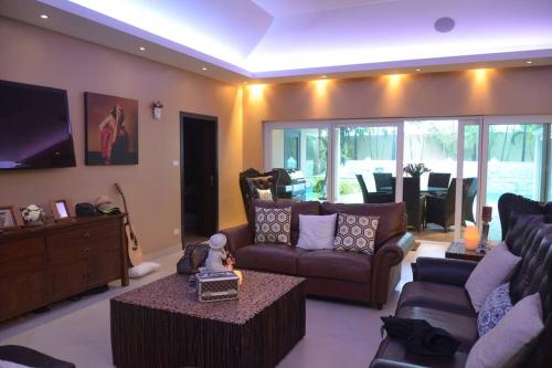 a living room with a couch and a tv at 4BRLuxury pool villa near Siam Country club (golf) in Ban Hui Yai Muk