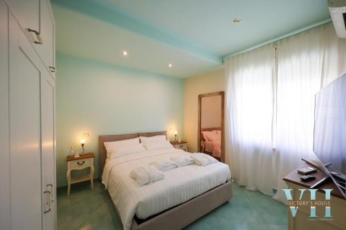 a bedroom with a bed with white sheets and a window at Victory's Luxury House with Jacuzzi on the Roof in Ischia