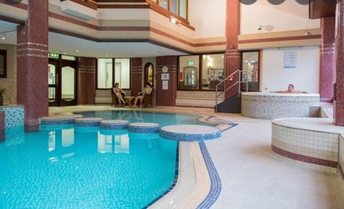 a large swimming pool in a large building at Charming Cottage near Cartmel with free Spa access in Holker