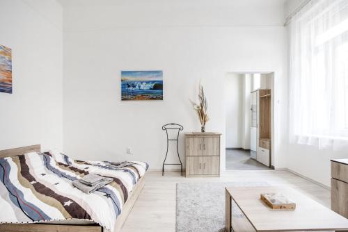 una habitación blanca con una cama y una mesa en Lovely studio in the heart of Budapest, en Budapest