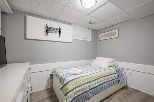 a bedroom with a bed with a striped blanket at 176 Sudbury Lane Hyannis Cape Cod - - Need Name in Hyannis
