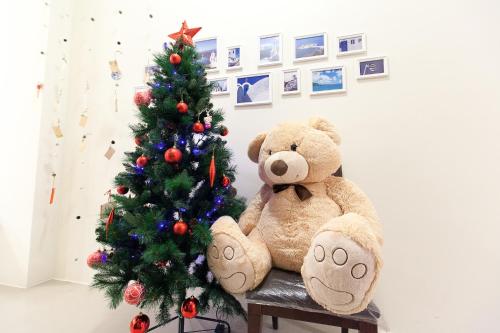 a teddy bear sitting next to a christmas tree at B-wei B&B in Hualien City