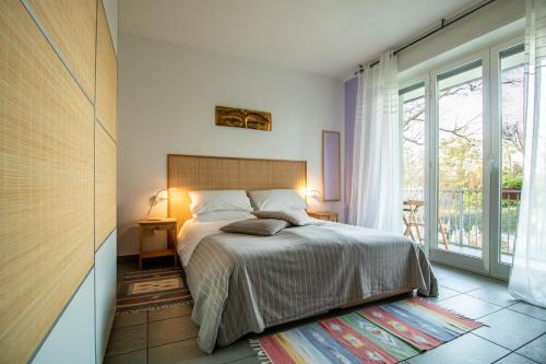 a bedroom with a bed and a large window at Oasi Degli Dei in Ranco