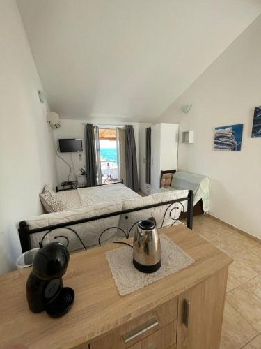 a room with a large bed and a table in it at Apartmani Cesarec in Vrboska