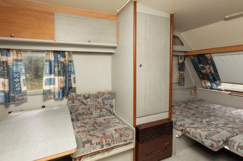 Habitación pequeña con 2 camas y mesa. en Camping Malkiq oazis en Ezerets