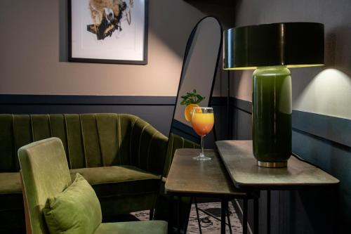 a room with a chair and a table with a drink at Best Western Plus Nice Cosy Hotel in Nice