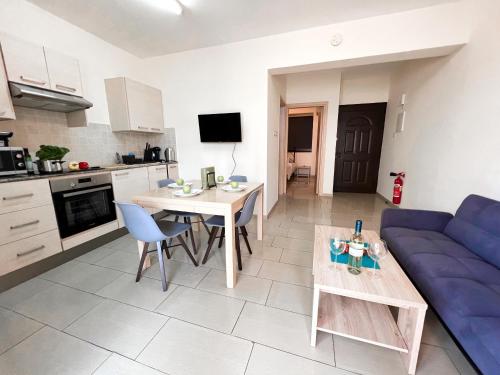 a living room with a blue couch and a table at Antiparos 1 bedroom APT Kyklades in Paralimni