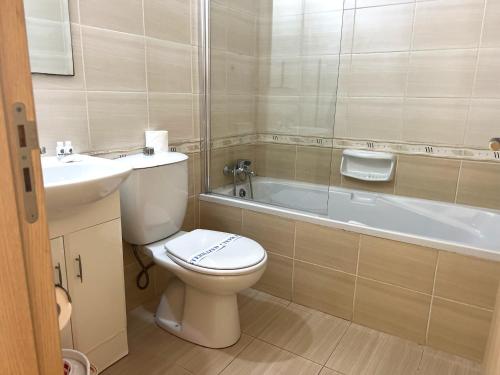 a bathroom with a toilet and a sink and a bath tub at Antiparos 1 bedroom APT Kyklades in Paralimni