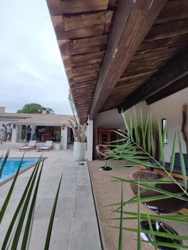 a patio with a pool and a wooden ceiling at Hotel Bastide & SPA - Villa de Lourmarin in Lourmarin