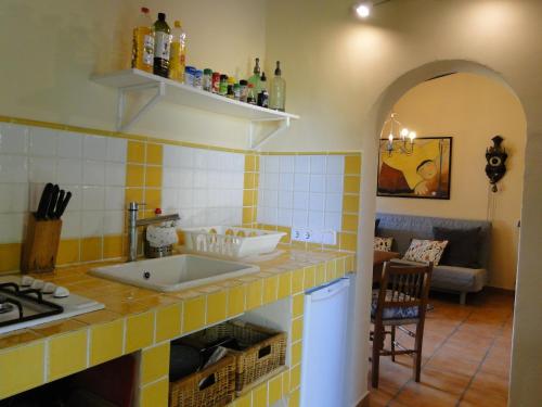 a kitchen with a yellow and white tiled wall at Finca Caballo Blanco in Montuiri