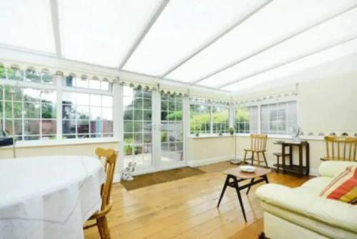 a room with a bed and a living room with windows at Lynton Road in London