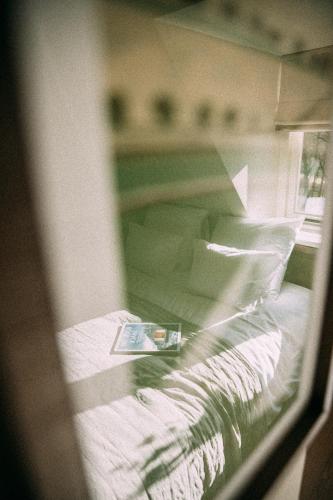 a window view of a bed with a book on it at de Wever Lodge in Otterlo