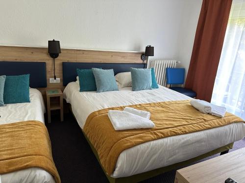 Ένα ή περισσότερα κρεβάτια σε δωμάτιο στο Hôtel Le Blainon