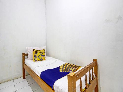 ein kleines Schlafzimmer mit einem Holzbett in einem Zimmer in der Unterkunft SPOT ON 92539 Luqman Kostel Syariah in Semarang
