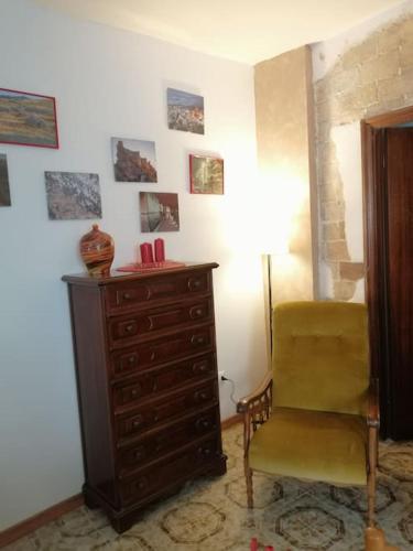 a room with a chair and a dresser and a lamp at La casa di Cinzia in Pettorano sul Gizio
